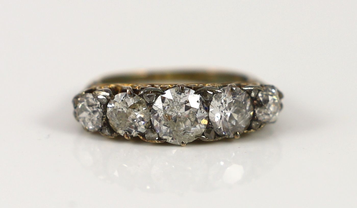 An early 20th century 18ct gold and graduated five stone diamond set half hoop ring